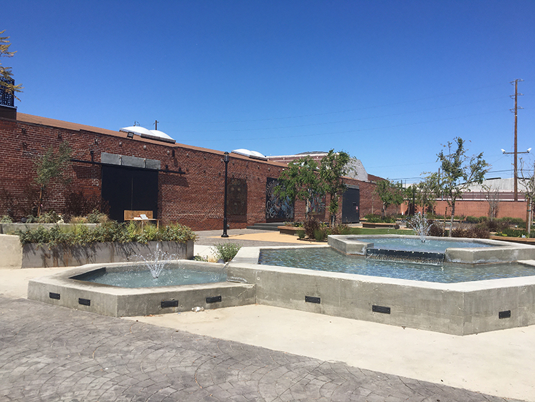 Fountains, trees and red brick warehouses in The Beehive.