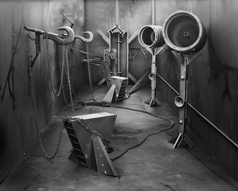 A black and white image of industrial machinery and chains in a room