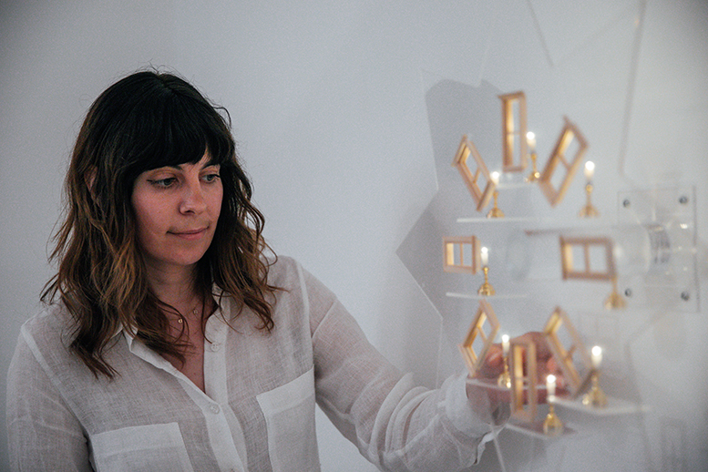 A photo of Nina touching a 3D sculpture made up of windows and lights.