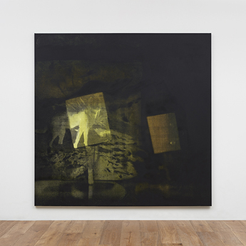 An installation view of Yellow Dust, which looks like a photo negative of abstract yellow shapes against a black background.