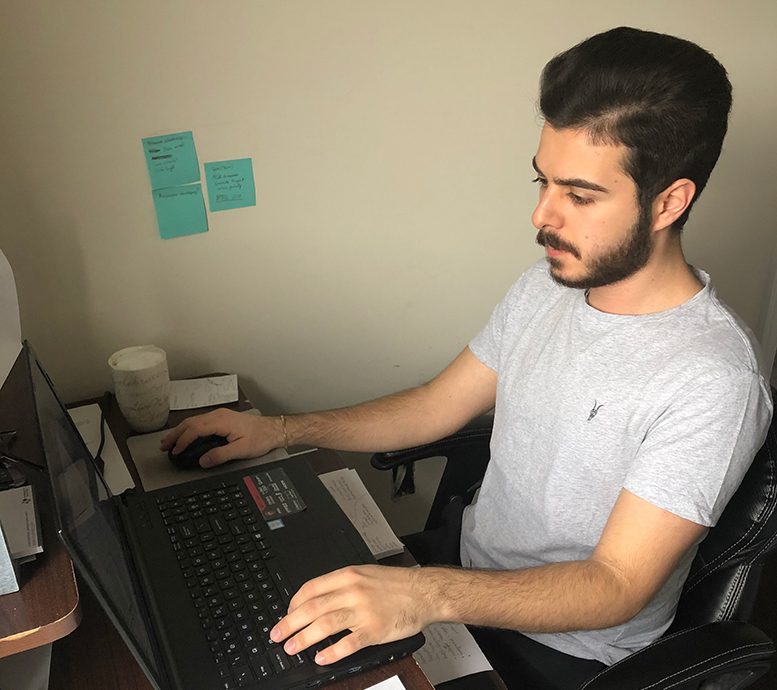 A student at a desk looks at his computer.